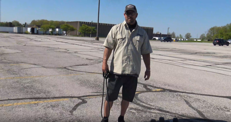 Derek Knowles, a CRST driver, demonstrates a simple workout routine in a parking lot, sharing fitness tips for truckers to stay active on the road.
