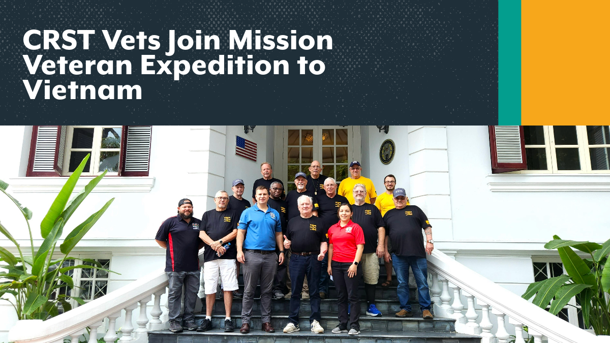 Three CRST Vietnam Veterans recently traveled back to Vietnam as part of the 2023 Mission Veteran Expedition – Director of Capacity Solutions John Frey, CRST Specialized Solutions Driver Johnnie Lee McGlothen, and CRST Senior Fleet Manager Dock Peppers posing in front of white building